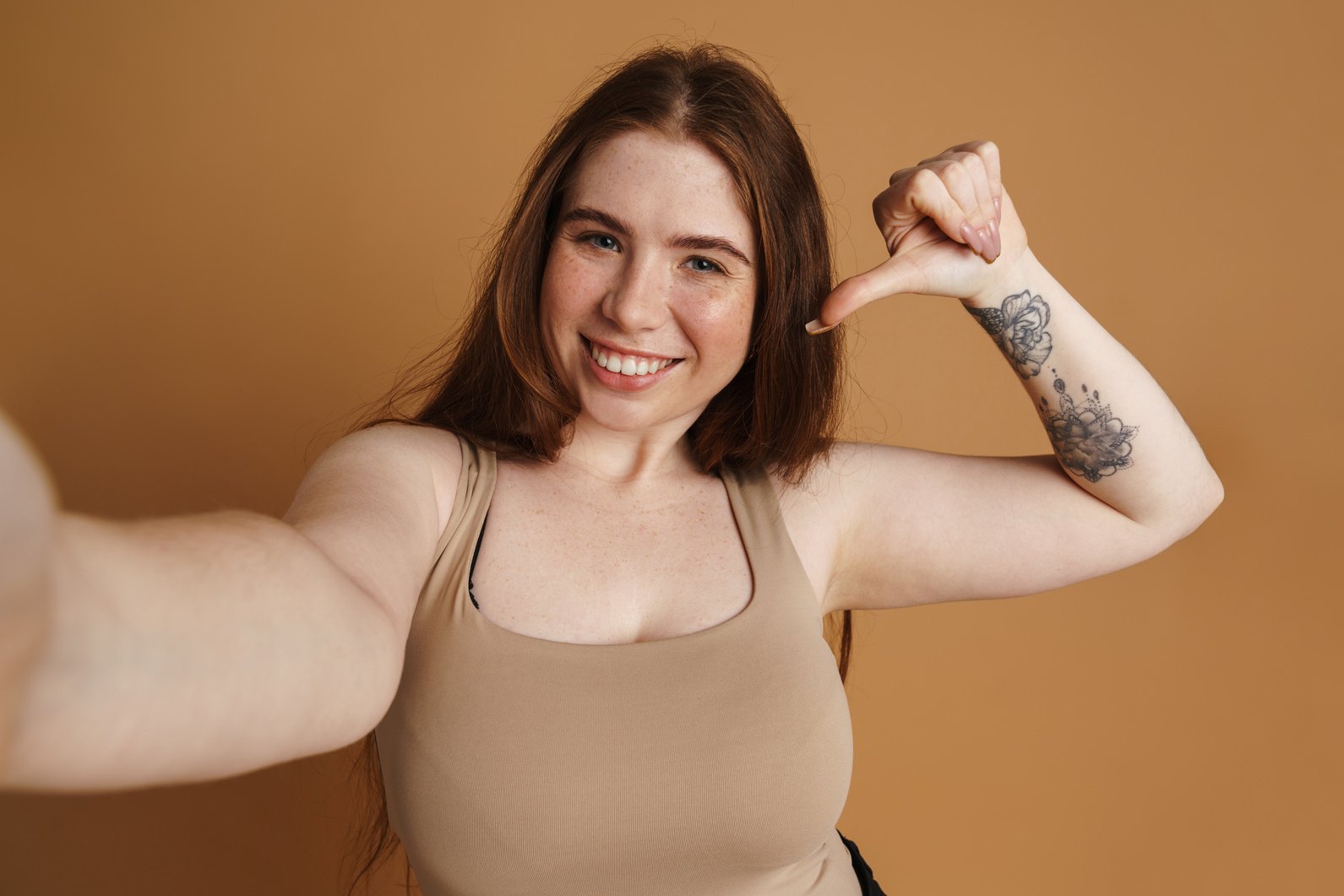 Smiling Young plus Size Woman Posing over Beige